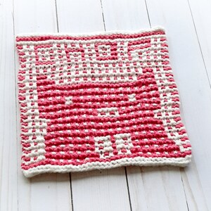 May include: A pink and white knitted dishcloth with a geometric pattern.