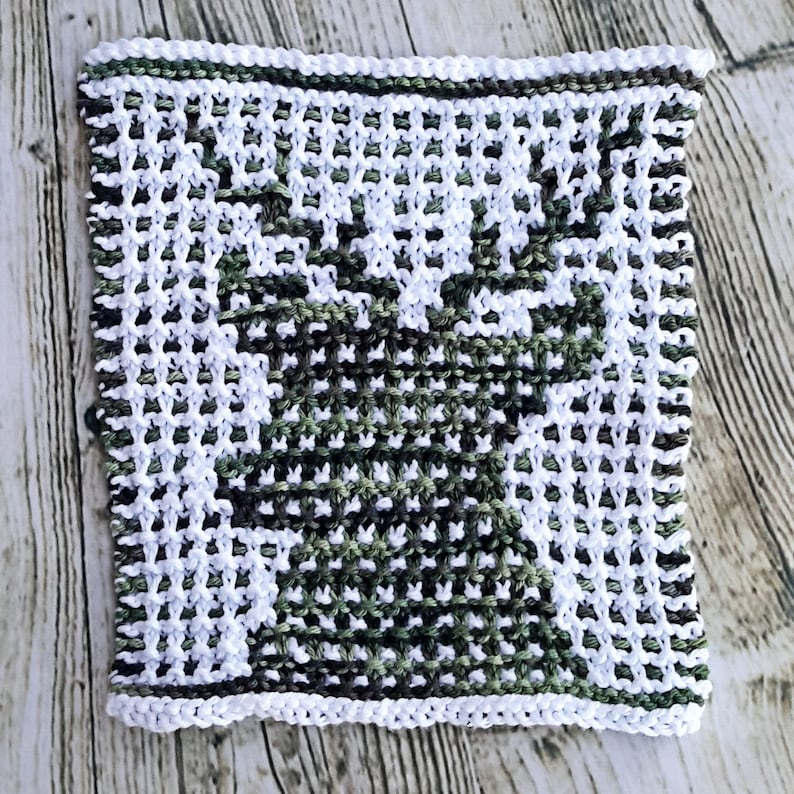 May include: A white and green knitted dishcloth with a geometric pattern. The dishcloth is square and has a white border.
