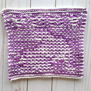 Puede incluir: Un pa&ntilde;o de cocina de punto morado y blanco con un patr&oacute;n texturizado.