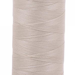 May include: A spool of beige thread with an orange plastic top and bottom.