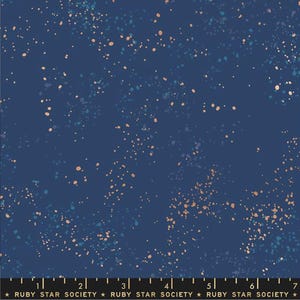 May include: A navy blue fabric with a scattered pattern of small, light blue and peach-colored dots. The fabric has a subtle shimmer.