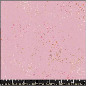 May include: Pink fabric with a speckled pattern of gold, white, and orange dots. The fabric has a subtle texture and a soft, light pink color.