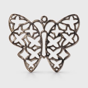 May include: A silver-colored butterfly pendant with a cutout design. The wings are adorned with cross-shaped cutouts, and the body has a vertical cutout. The pendant has a small loop at the top for hanging.