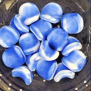 May include: A collection of blue and white agate stones with a swirling pattern. The stones are smooth and polished, and they have a variety of shapes and sizes.