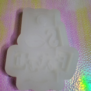 Puede incluir: Molde de silicona blanco con las palabras "I'm a " y "CRANK" en letras en relieve.