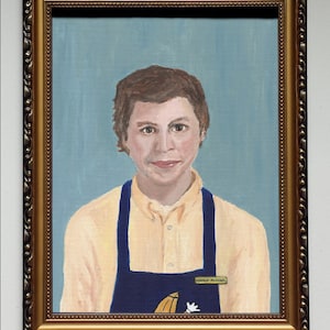 May include: A framed painting of a person wearing a yellow shirt and a blue apron with the name tag "George Michael". The background is a light blue color.