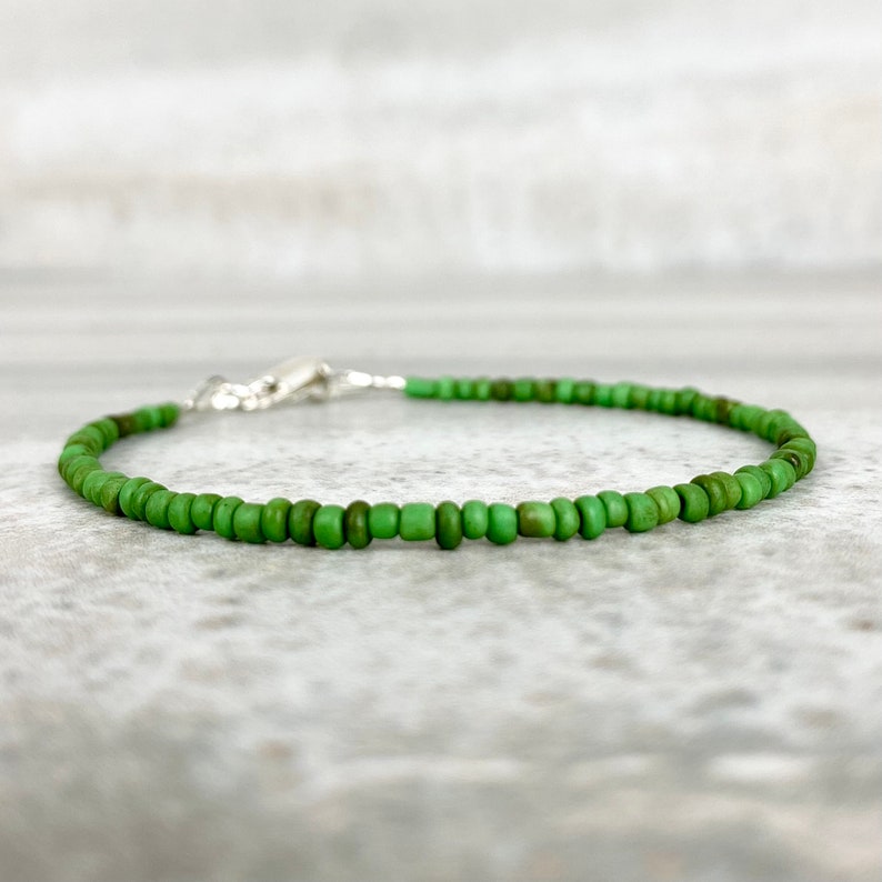 May include: A delicate green beaded bracelet with a silver clasp.