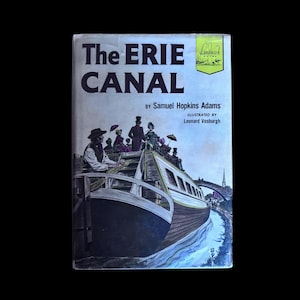 Puede incluir: Un libro antiguo titulado "The Erie Canal" de Samuel Hopkins Adams, ilustrado por Leonard Vosburgh. La portada presenta una ilustración detallada de un barco de canal con pasajeros, sobre un fondo azul y verde. El libro es un Landmark Book.