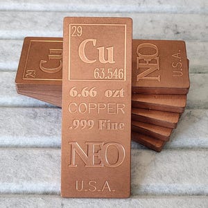 May include: Copper bars with the periodic table symbol Cu, atomic number 29, and the weight 63.546. Each bar is stamped with "6.66 ozt COPPER .999 Fine" and "NEO U.S.A.". The bars are a reddish-brown color and stacked.