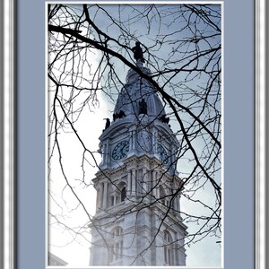 K&ouml;nnte beinhalten: Eine Nahaufnahme des Uhrturms des Philadelphia City Hall, mit kahlen &Auml;sten im Vordergrund.