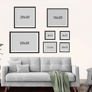 K&ouml;nnte beinhalten: Eine wei&szlig;e Wand mit einem grauen Sofa und einem Stuhl. An der Wand h&auml;ngen 7 schwarze Bilderrahmen mit wei&szlig;en Passepartouts. Die Rahmen sind unterschiedlich gro&szlig; und haben die Ma&szlig;e in schwarzer Schrift auf den Rahmen. Die Ma&szlig;e sind 20x20, 16x20, 20x30, 8x12, 8x10, 11x14 und 10x10.