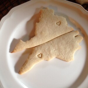 May include: Two sugar cookies shaped like a state outline with a heart cutout on each cookie.