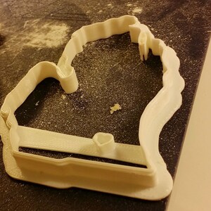 May include: White plastic cookie cutter shaped like the state of Michigan.