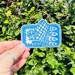 Op de afbeelding: Een blauwe en witte sticker met een ontwerp van een blikje sardines en de tekst "with fresh".