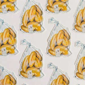 Op de afbeelding: Een vel stickers met een herhalend patroon van gele stokbroden in doorzichtige plastic zakken. Elke zak heeft een wit prijskaartje.