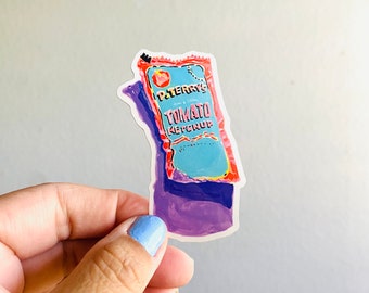 Pode incluir: Um adesivo de um pacote de ketchup com fundo roxo. O pacote é vermelho, rosa e azul com o texto "P. Terry's Tomato Ketchup" nele.