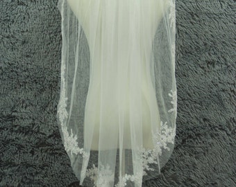 May include: A white bridal veil with a delicate lace trim. The veil is made of soft tulle and has a scalloped edge.