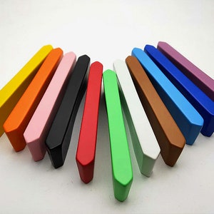 May include: A set of 12 colorful cabinet door pulls in various colors, including yellow, orange, pink, black, red, green, white, brown, blue, light blue, dark blue, and purple.