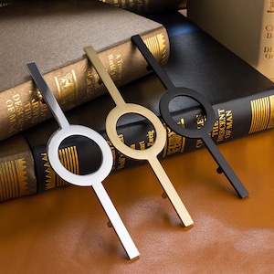 May include: Three decorative cabinet door pulls with a circular design. The pulls are made of metal and come in gold, silver, and black.