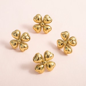 May include: Four gold-coloured metal flower-shaped drawer pulls.