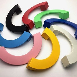 以下が含まれることがあります： カラフルな半円形のキャビネットドアプルのおまかせセット。プルは滑らかで丈夫な素材で作られており、黒、赤、緑、青、黄、ピンク、白など、さまざまな色からお選びいただけます。