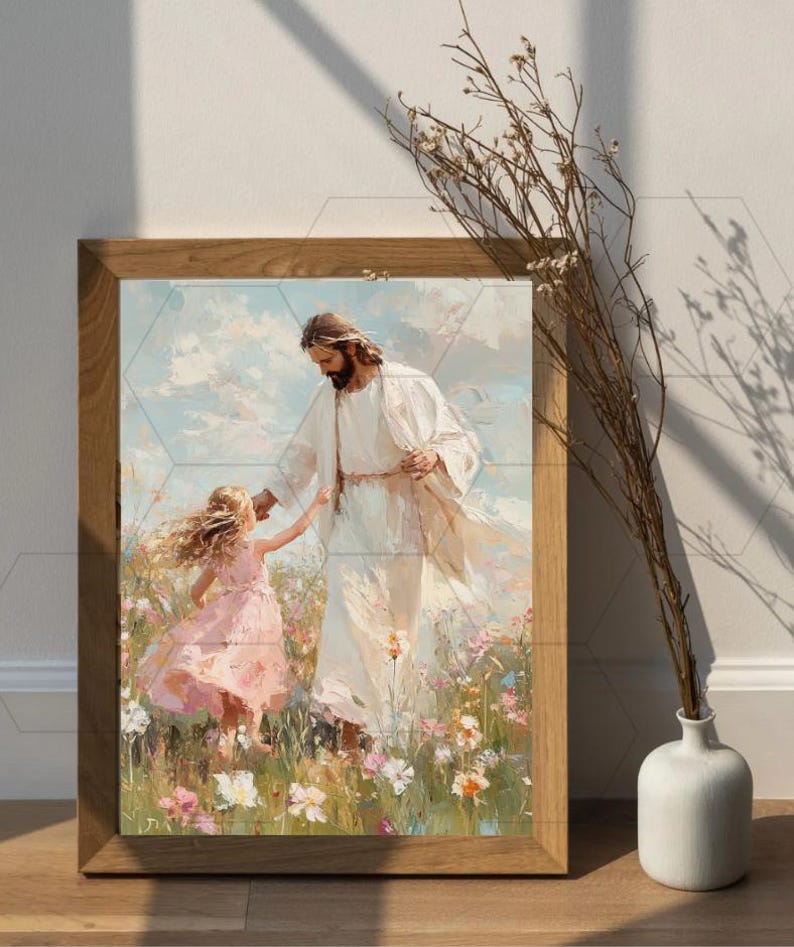 May include: A framed print depicts a figure in white robes with a child in a pink dress in a field of flowers. The artwork has a soft, painterly style with a light color palette. The frame is made of light brown wood.