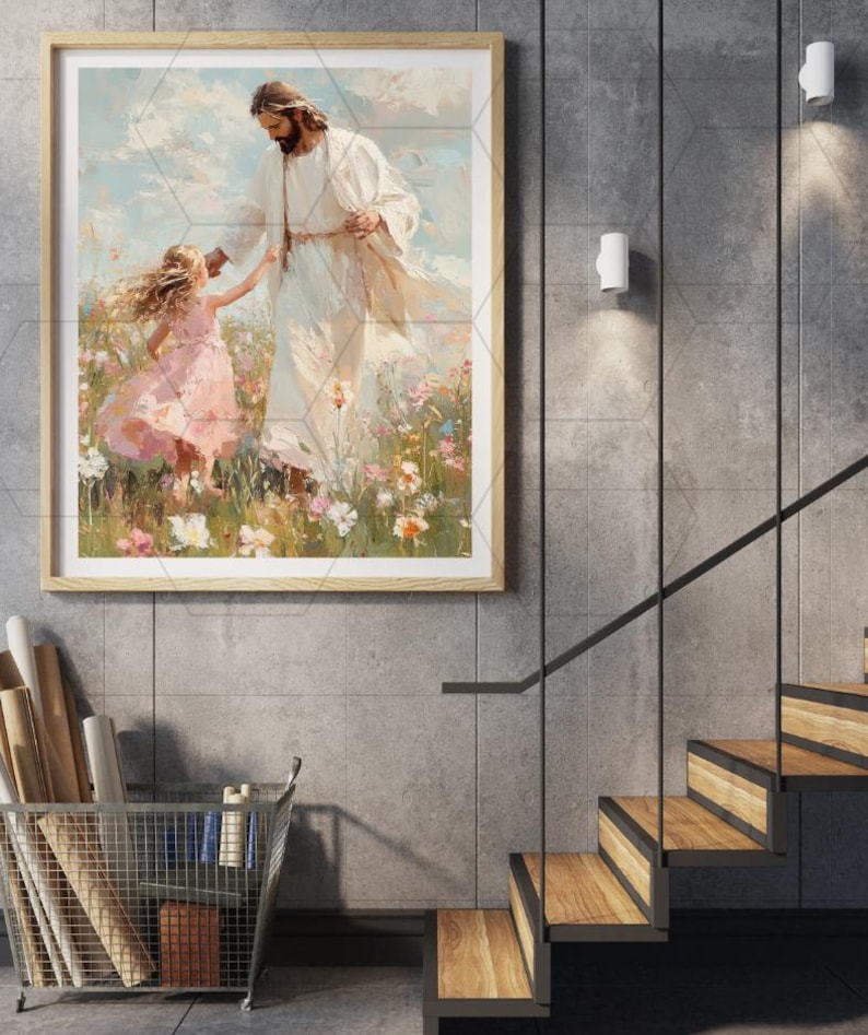 May include: A framed art print depicts a figure in white robes with a child in a pink dress in a field of flowers. The artwork is in a light wood frame, displayed on a gray tiled wall. The scene evokes a sense of peace and serenity.