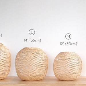 Op de afbeelding: Vier ronde, geweven bamboe hanglampenkappen in verschillende maten: XL (40 cm), L (35 cm), M (30 cm) en S (25 cm).