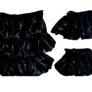 May include: Several black ruffled fabric pieces are arranged against a white background. The pieces appear to be made of a shiny, possibly satin-like material. The fabric is gathered and layered, creating a voluminous effect.