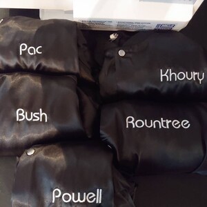 Puede incluir: Cinco chaquetas de sat&eacute;n negro con nombres bordados en blanco: Pac, Bush, Khoury, Rountree y Powell.