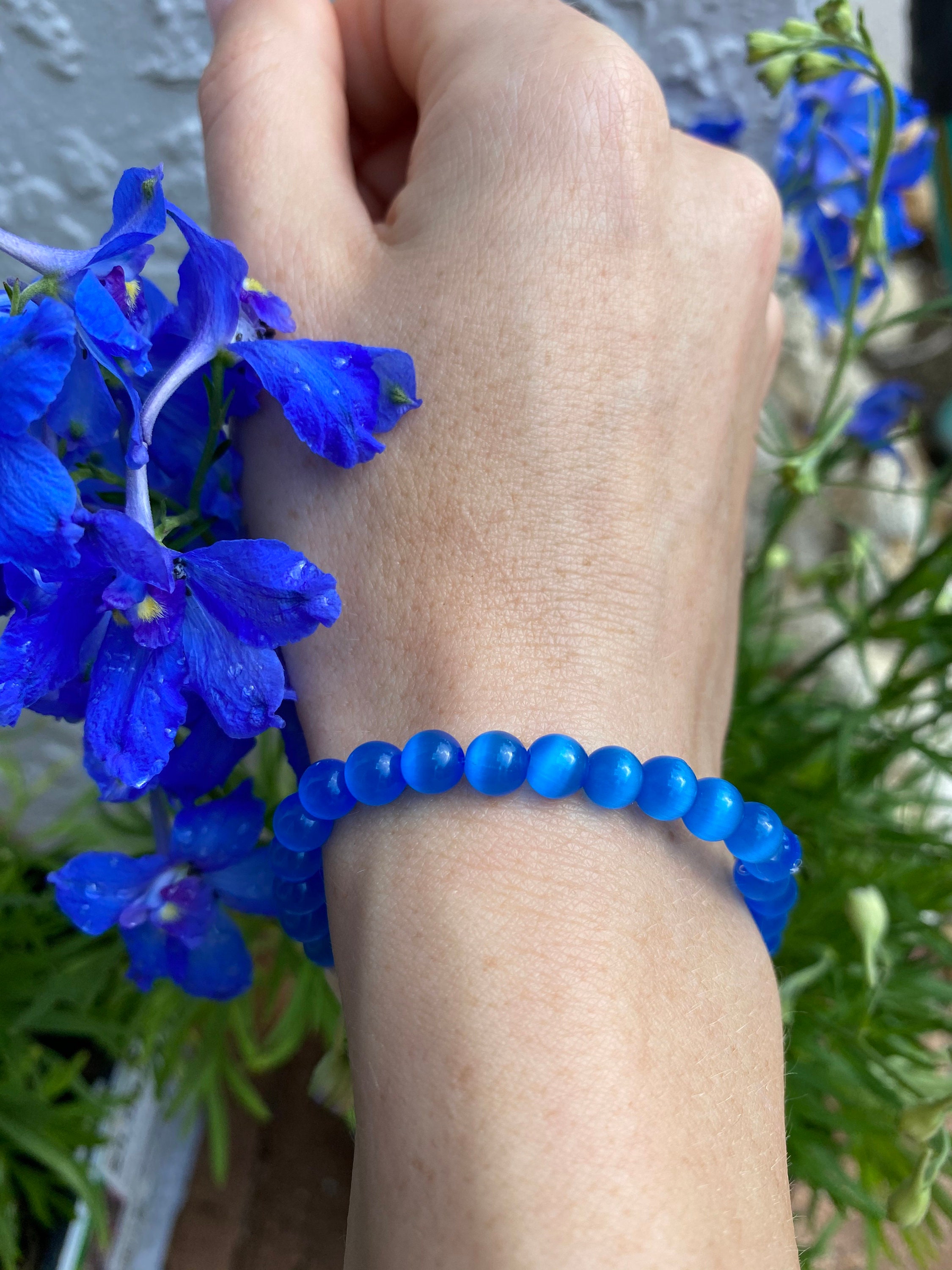 Dark blue cats eye crystal beaded bracelet with a lettered olive seashell