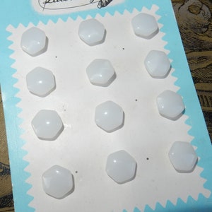 May include: A card with the text "Latest Style" printed on it. The card has a white background and a blue border. There are 12 white, hexagonal buttons arranged in rows on the card.