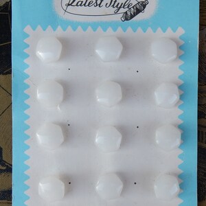 May include: A card with the text "Latest Style" printed on it. The card has 12 white, hexagonal buttons attached to it.