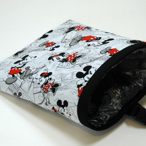 May include: A white fabric bag with a black trim and a black plastic clip. The bag is printed with a black and white cartoon image of Mickey Mouse and Minnie Mouse.