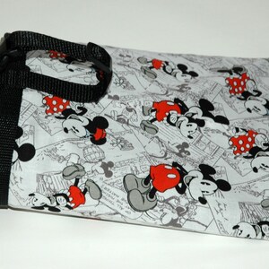 May include: A white fabric bag with a black strap and a repeating pattern of Mickey Mouse and Minnie Mouse in black and white with red accents.