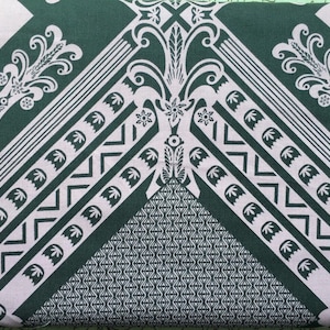 Może przedstawiać: Tkanina w kolorze zielonym i białym z geometrycznym wzorem. Wzór zawiera powtarzający się motyw trójkątów, zygzaków i wzorów kwiatowych.