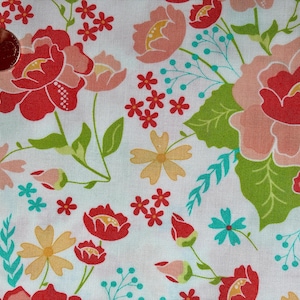 Può includere: Un tessuto bianco con un motivo floreale composto da grandi fiori rossi e rosa, fiori gialli più piccoli e accenti color turchese brillante. Una moneta color rame è posizionata nell'angolo in alto a sinistra per la scala, misurando 2 cm di diametro.