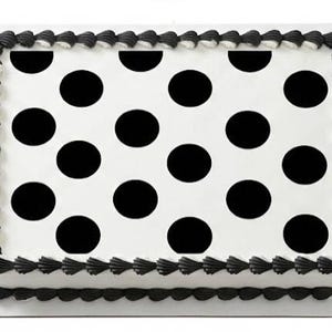 May include: A rectangular cake with a white base and large black polka dots. The edges are decorated with a black, scalloped frosting border. A simple, elegant design for a celebration.