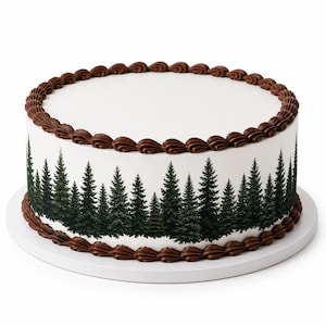 May include: A round cake with smooth white frosting featuring a printed forest of dark green pine trees around the sides. The top and bottom edges are decorated with a continuous border of piped brown chocolate frosting swirls.