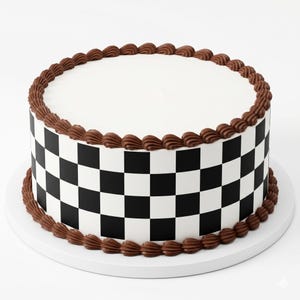 May include: A round cake with a smooth white top surface and a side featuring a black and white checkered pattern. The top and bottom edges of the cake are decorated with a continuous border of brown piped frosting swirls.