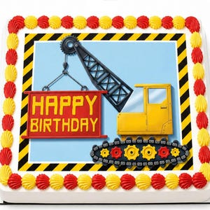 May include: A square birthday cake decorated with a construction theme. The cake features a yellow and black crane lifting a red sign that says "HAPPY BIRTHDAY". The cake is decorated with red and yellow frosting.