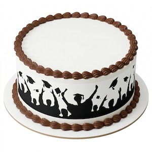 May include: A round white cake with chocolate frosting trim and a black graduation-themed design around the sides. The design features silhouettes of graduates throwing their caps in the air. The cake sits on a white cake board.