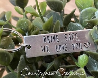 May include: Silver keychain with a metal tag that reads "Drive Safe, We Love You" with a heart symbol.
