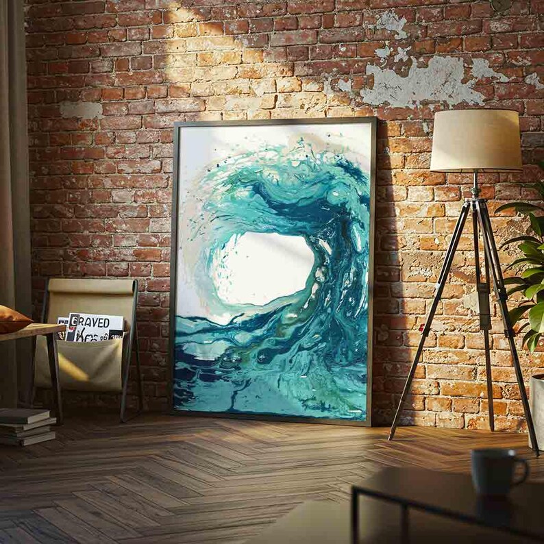 May include: A rectangular framed wall art print featuring an abstract fluid painting of a large ocean wave in shades of teal, turquoise, and deep blue. The artwork displays swirling water patterns with white highlights, set against a white background.