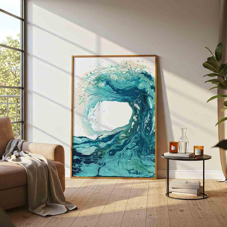 May include: A rectangular wall art print featuring an abstract fluid painting of a large ocean wave in shades of teal, turquoise, and deep blue. The artwork is enclosed in a thin, light-colored wooden frame and displayed on a plain wall.