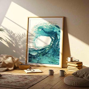 May include: A framed rectangular wall art print featuring an abstract fluid painting of a crashing ocean wave in shades of teal, turquoise, and deep blue. The artwork is displayed in a light-colored wooden frame with a white mat border.