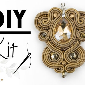 May include: DIY Kit featuring a gold pendant with a large, faceted, amber-coloured crystal surrounded by intricate, woven wire designs.