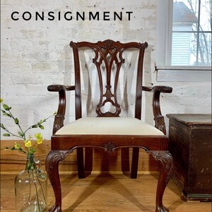 May include: A mahogany wood chair with a carved back and cabriole legs. The chair has a white fabric seat and is in good condition.