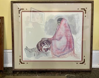 May include: A framed print featuring a person wrapped in a pink shawl, sitting and holding a patterned ceramic pot. The artwork uses muted tones and fine lines, set within a light-colored mat and a dark wood frame with geometric corner accents.