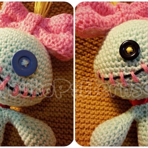 May include: A crocheted blue Stitch doll with pink yarn hair and a pink bow. The doll has black yarn stitching around the eyes and mouth, and blue and black buttons for eyes.